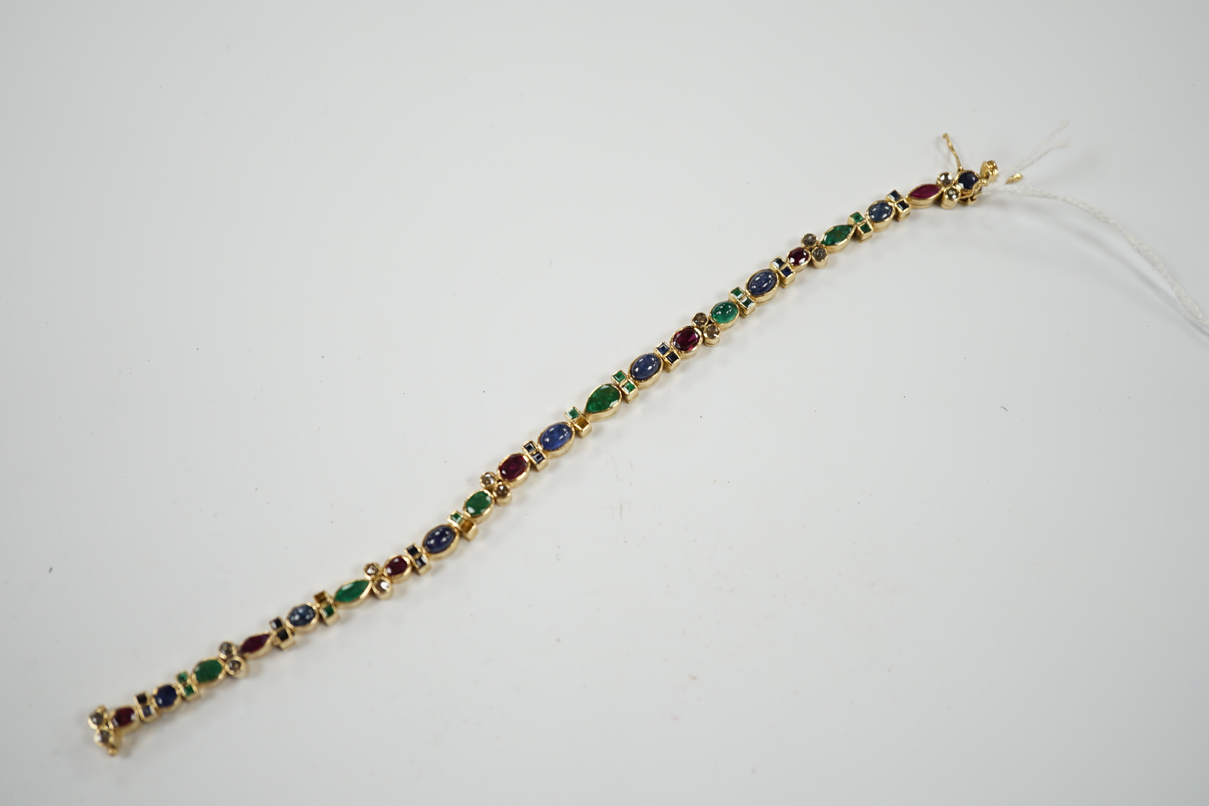 A yellow metal, diamond, ruby, sapphire and emerald cluster set line bracelet, 18.6cm, gross weight 18.3 grams.